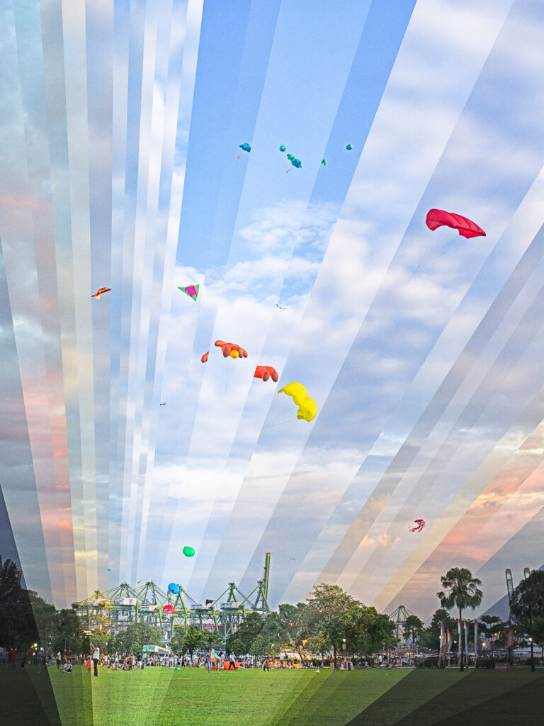 Kites over West Coast Park, the sky cut into rays from different times of day